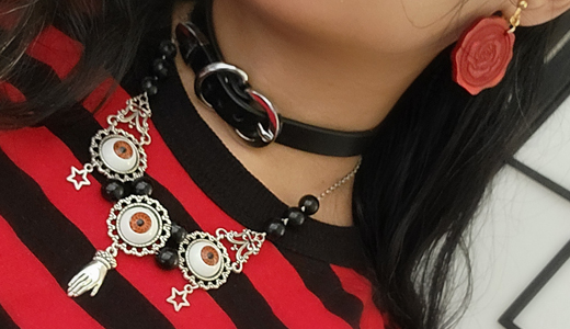 Detail photo of accessories: oracle necklace, choker, and wax seal earring.
