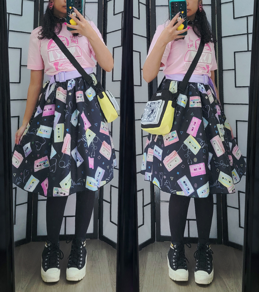 Black and pastel casual outfit with a colorful cassette tape print dress and pastel pink shirt.