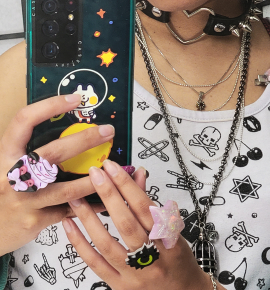 Close-up of layered necklaces, choker, and creepy cute rings.