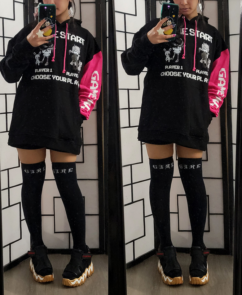 A black, white, and pink streetwear outfit with an oversized videogame themed hoodie and techwear sandals.