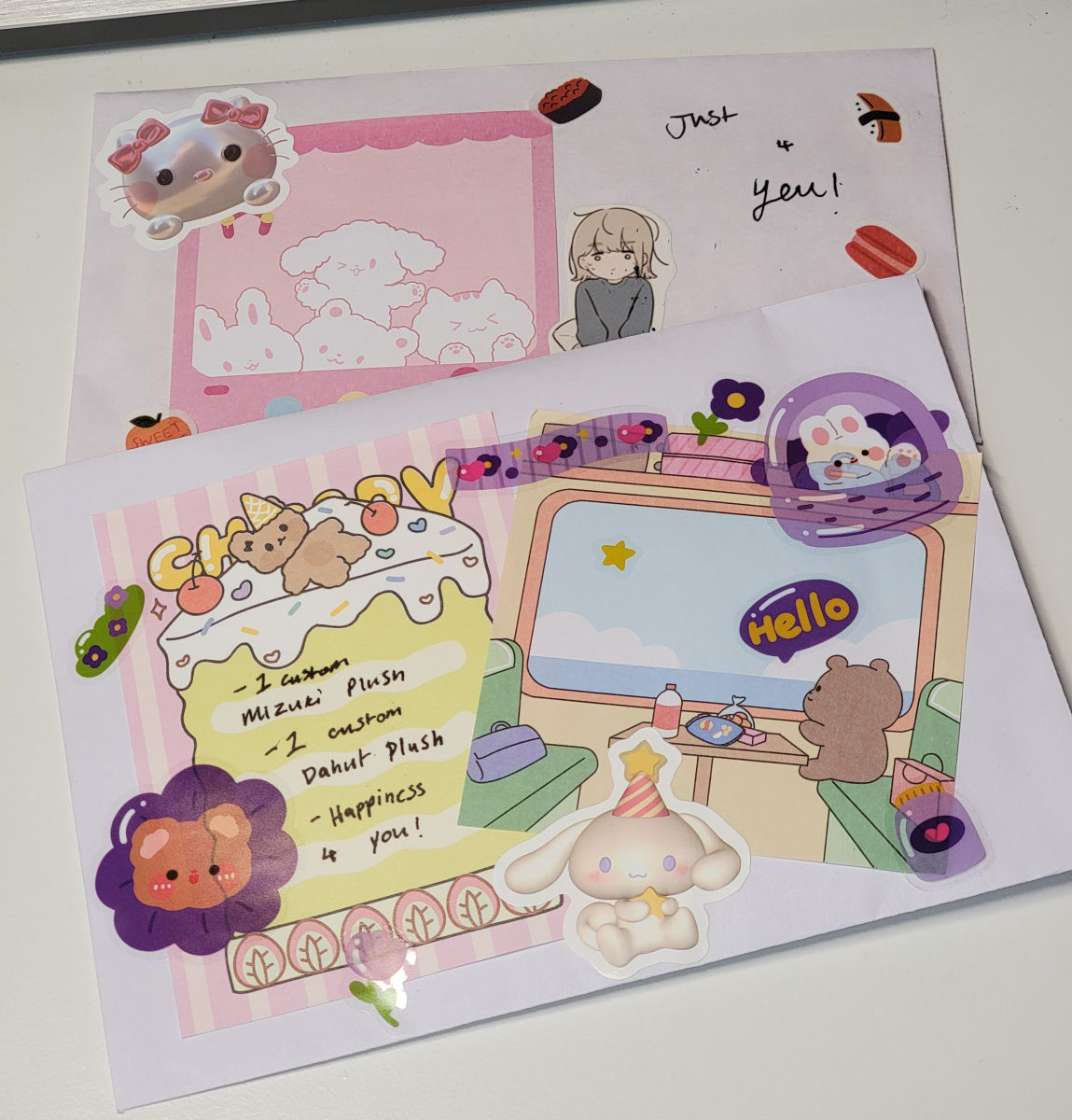 A photo showing two different envelopes decorated with cute stickers