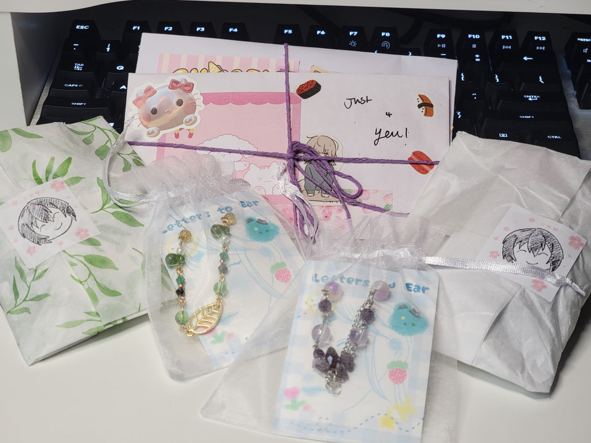 A photo showing delicately packaged goodies in cute bags, envelopes, and tissue papper wrapping.